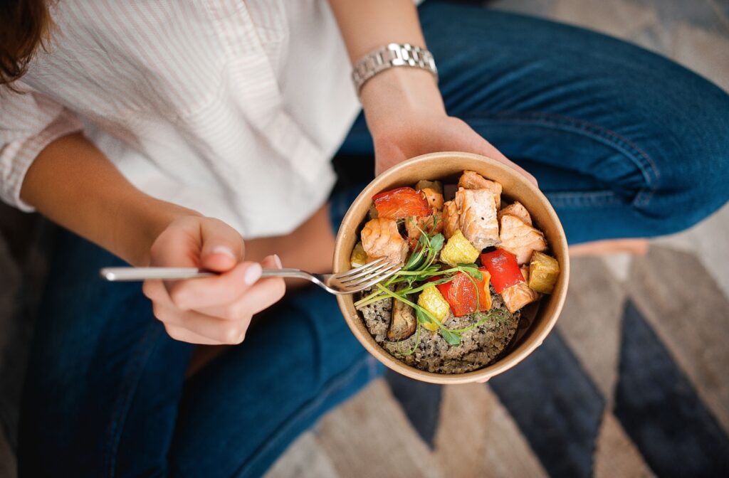 A woman enjoying a healthy meal to avoid caregiver burnout.