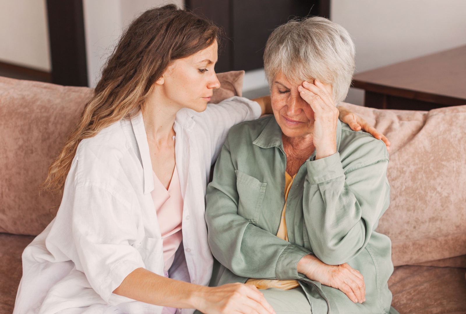An adult daughter trying to comfort her elderly mother as she experiences some negative emotions.