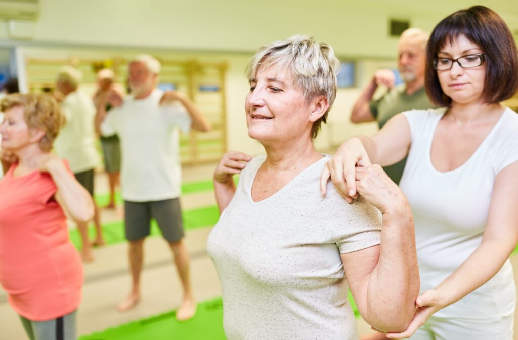 Seniors at an assisted living community doing posture exercises with an occupational therapist.